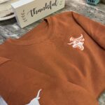 Burnt orange custom embroidered fleece sweater for local client in Austin TX
